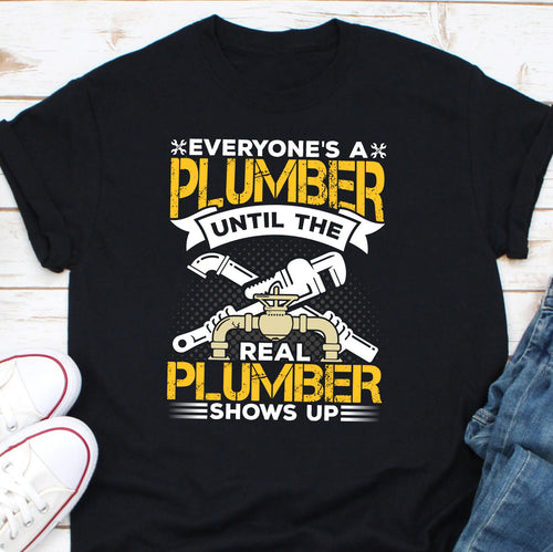 a t - shirt that says everyone's a plumber until the real plum